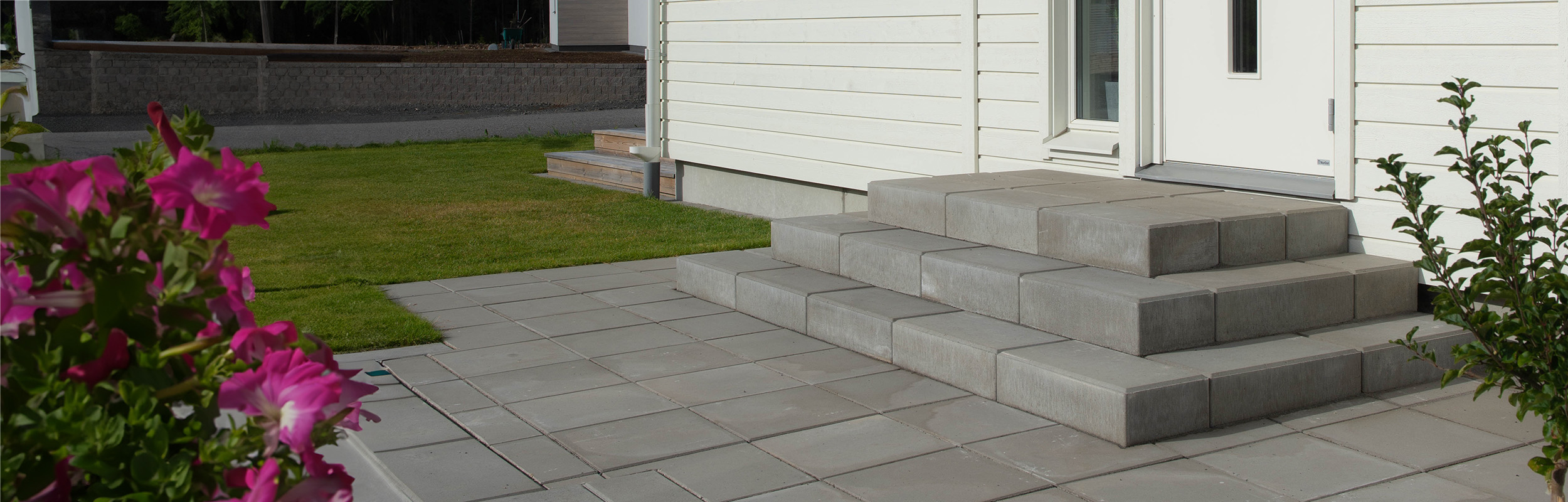 Grå betongtrappar med trappblock och marksten Funkis runt trappan