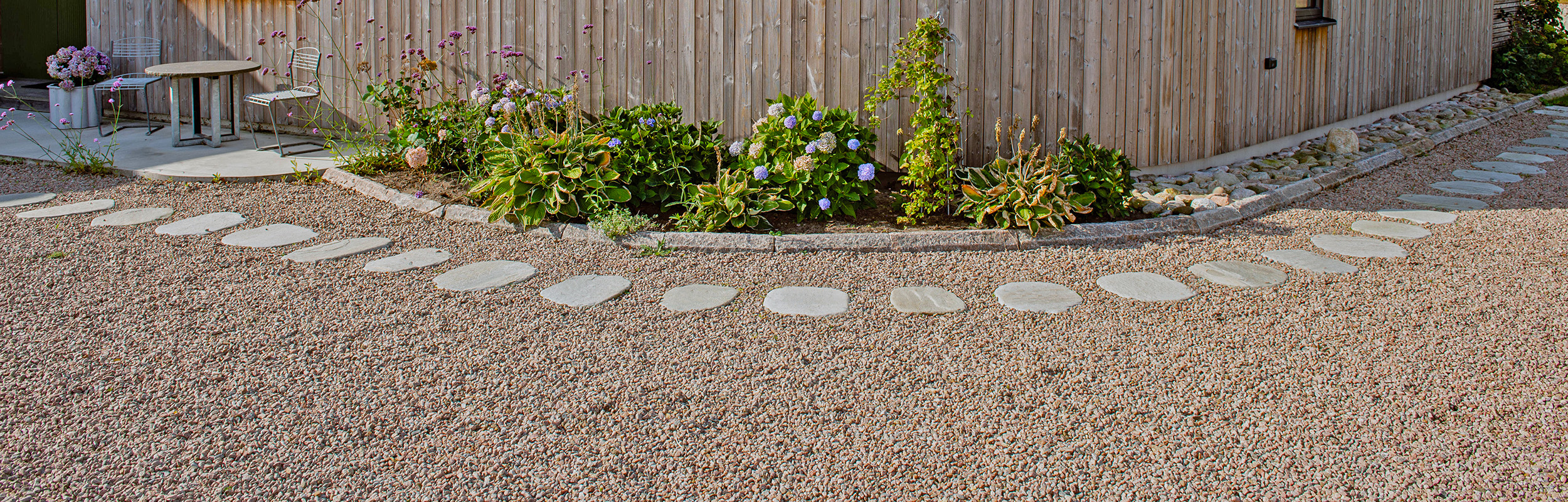 Stegsten i varmgrå skiffer och naturfärgat gårdssingel