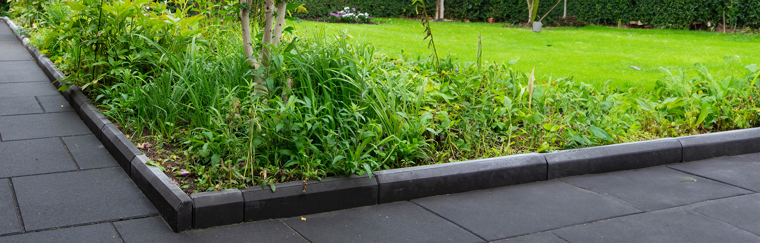 Marsten med kansten 50 i antracit som avgränsar mot grönområde